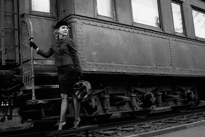 Full length of woman standing by railroad car
