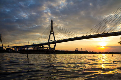 View of suspension bridge over sea during sunset