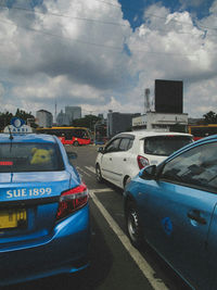 Cars on road in city against sky