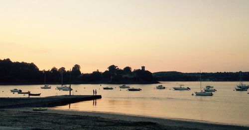 Boats moored in lake against clear sky