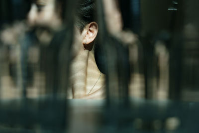 Portrait of young woman looking through window