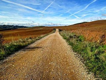 Dirt road passing through field