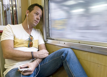 Man listening music while sitting in train