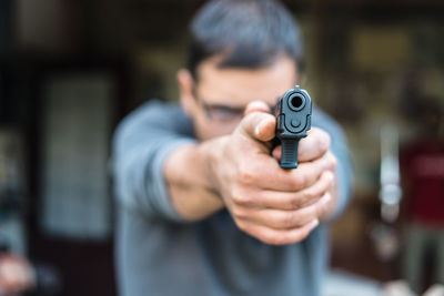 Midsection of man holding camera standing outdoors