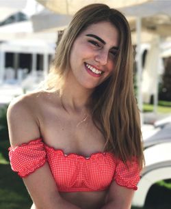 Close-up portrait of smiling woman with long hair outdoors