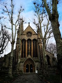 Low angle view of building and trees against sky