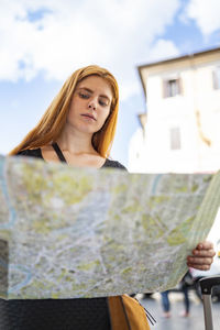 Portrait of a young woman in front of building