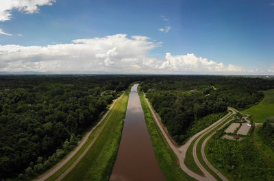 Panoramic shot of road amidst field against sky