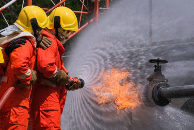 Firefighters spraying water on fire