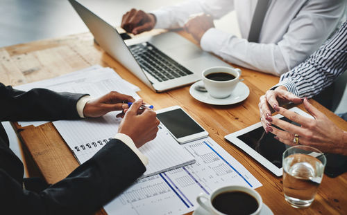 Midsection of business colleagues working on table