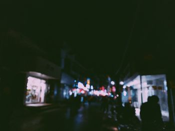 People on illuminated street at night