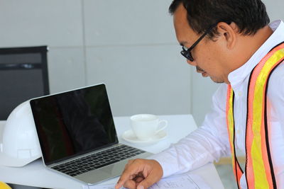 Low angle view of man using laptop on table