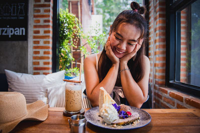 Woman looking away while sitting on table