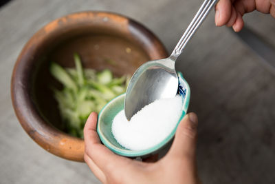Cropped hand of woman pouring salt in mortal and pastel