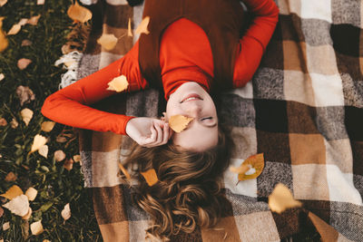 A pretty girl enjoys solitude drinks coffee walks in the autumn forest in nature in fall