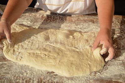 Midsection of person making dough