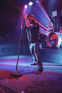 Man standing on illuminated stage at music concert