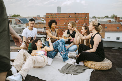 Happy multiracial friends enjoying party on rooftop