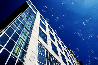 Low angle view of modern building against blue sky
