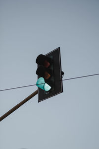 Low angle view of road signal against clear sky