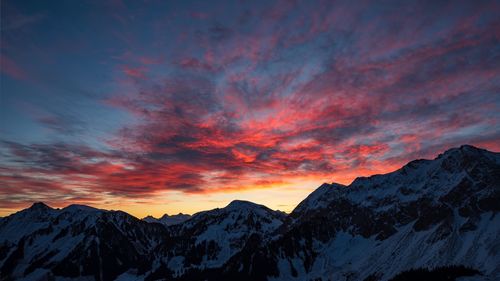 Scenic view of snowcapped mountains against sky during sunset