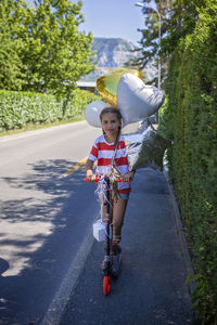 Rear view of woman with umbrella walking on road