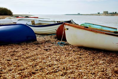 Boats moored on beach against sky