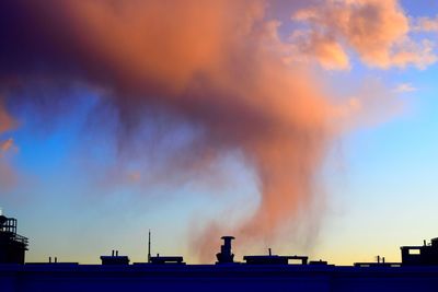 Low angle view of smoke emitting from chimney against sky