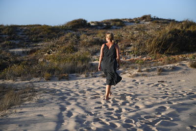 Rear view of woman walking on beach