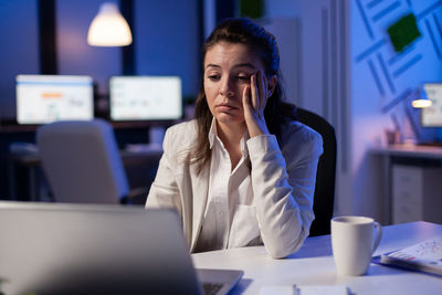 Woman using mobile phone while sitting on table