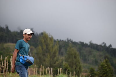 Young man standing on land against sky