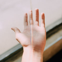 Cropped hand of woman with spectrum against wall