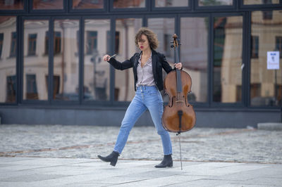 Full length of woman with violin on street