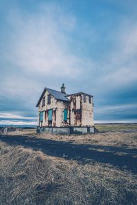 Abandoned building on field against sky