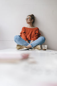 Young woman sitting on table thinking