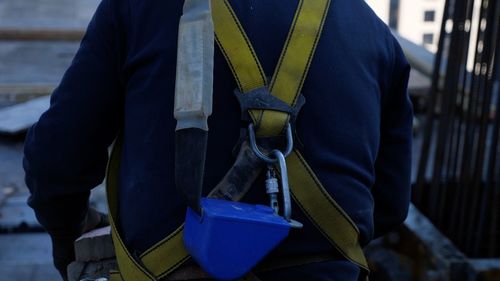 Close-up of construction worker wearing safety harness