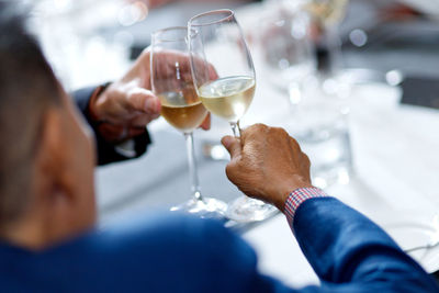 Midsection of man holding wine glass