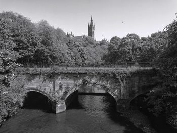 Arch bridge over river against sky