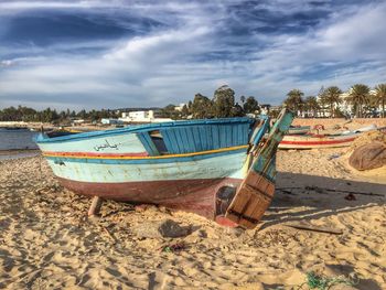 Boats moored on beach against sky