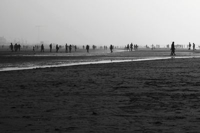 Group of people on field against clear sky