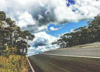 Empty road against cloudy sky