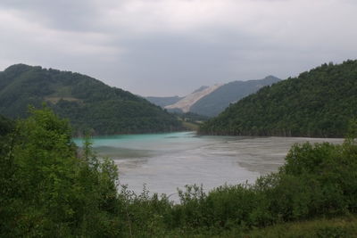 Scenic view of river and mountains against sky