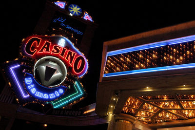 Low angle view of illuminated neon sign at night