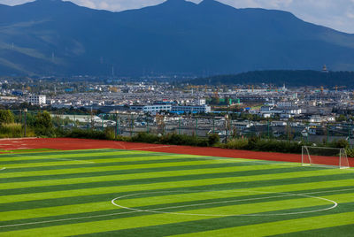 High angle view of soccer field and buildings against sky