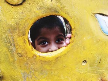 Playful boy seen through play equipment