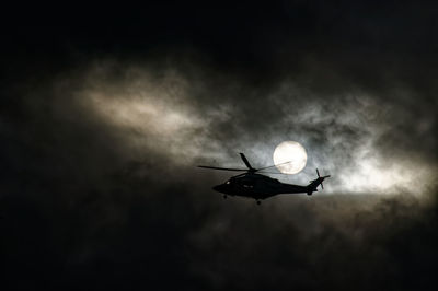 Low angle view of silhouette airplane against sky at night