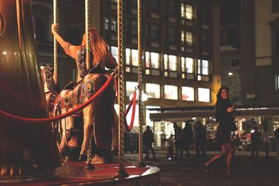 Illuminated carousel in amusement park at night