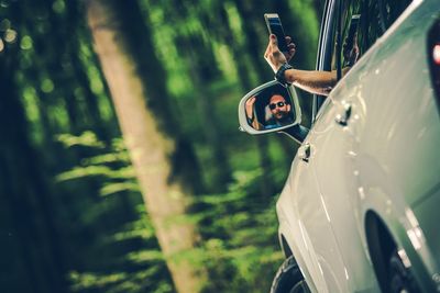 Man holding smart phone while sitting in car