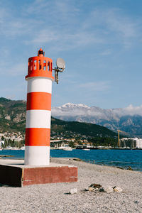 Lighthouse by sea against sky