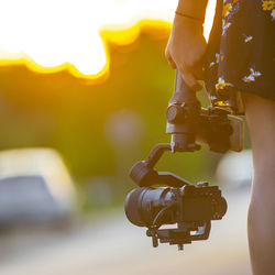 Close-up of camera hanging from car against sky